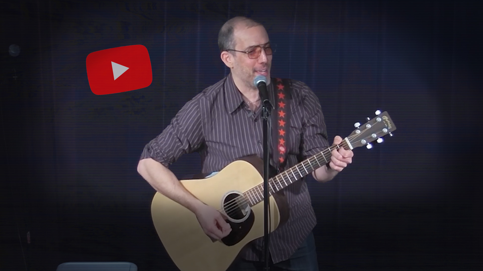 Screen cap of Rob on stage playing guitar. YouTube 'play' logo in upper left, vignette around photo, slight horizontal video glitch effect on background